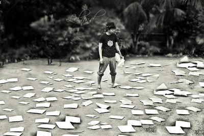 man standing on a field covered with scattered pieces of paper